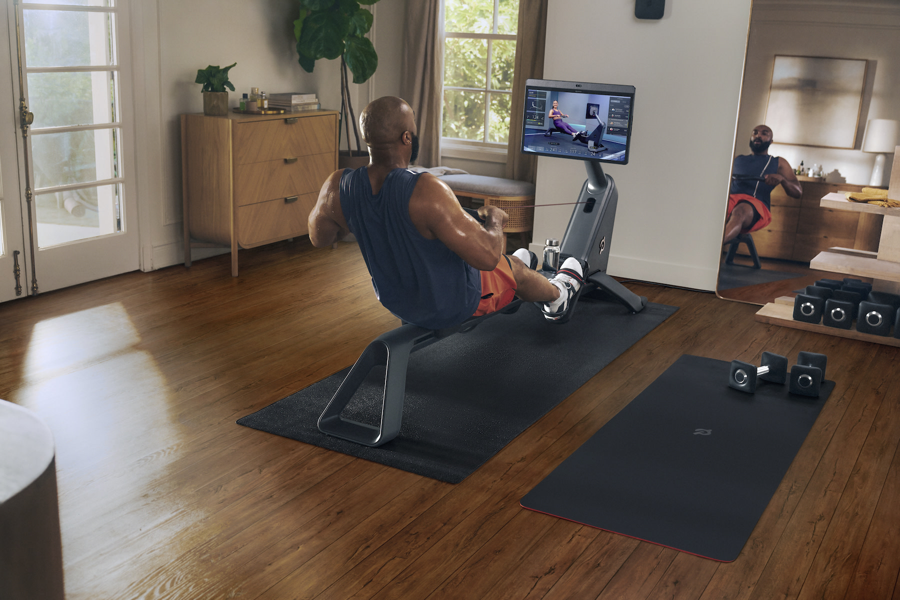 Man does rowing workout at home on Peloton Row