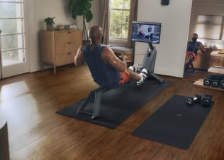Man does rowing workout at home on Peloton Row