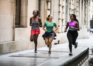 Group of women running through urban area