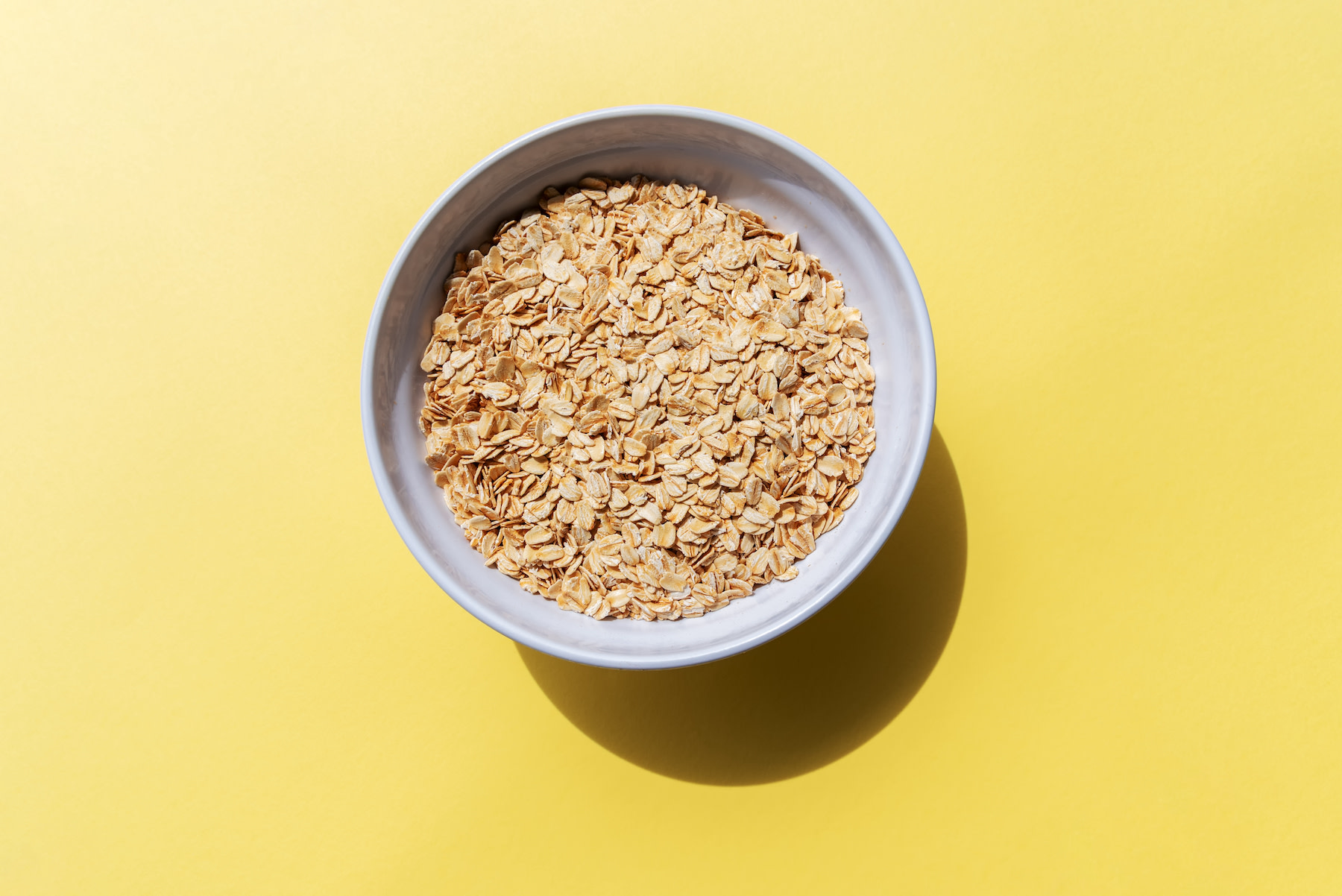 High-Fiber Foods: A bowl of oats on a yellow background.