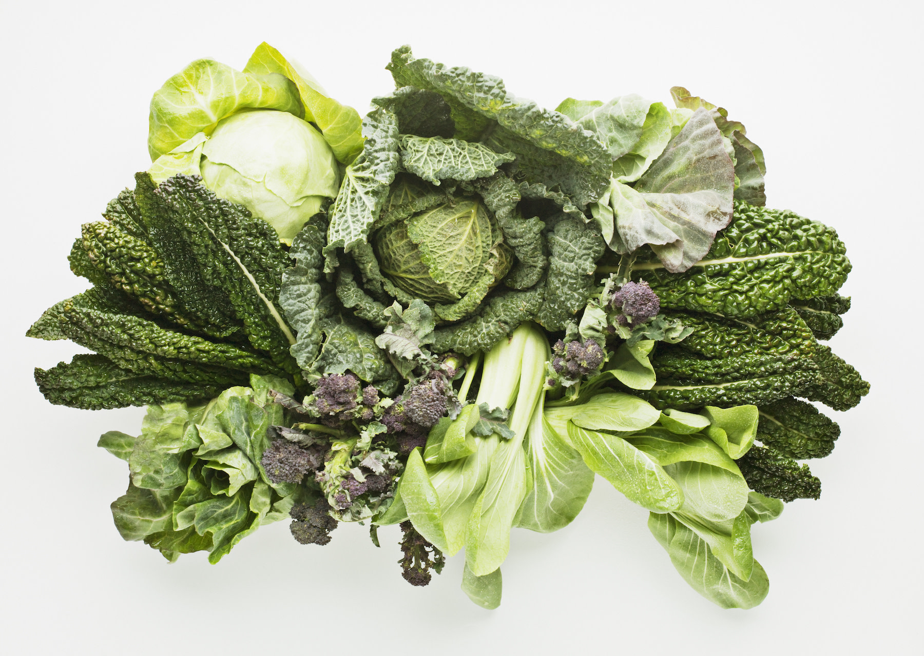 High-Fiber Foods: An array of leafy greens like kale and lettuce against a white background.