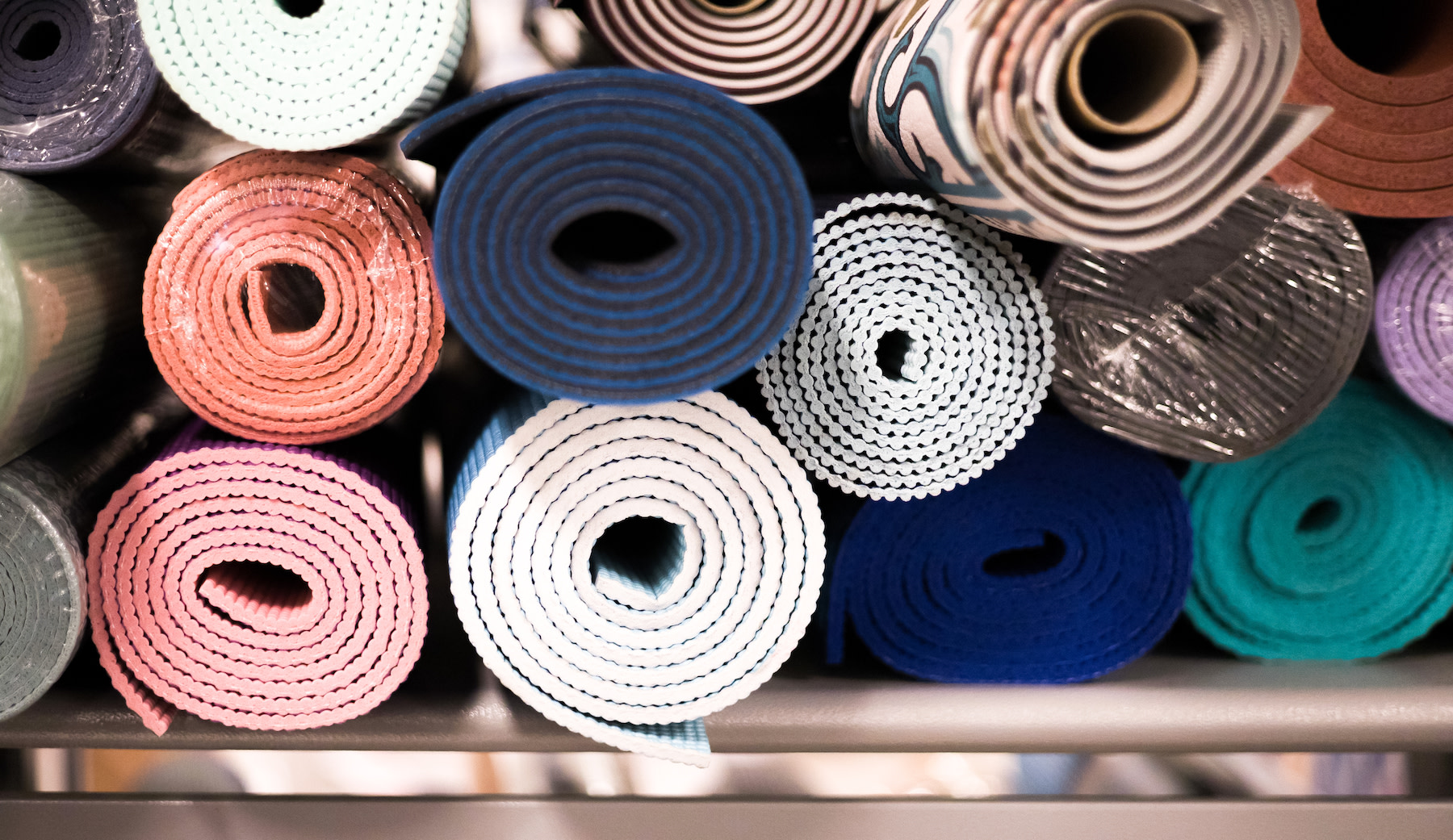 A bunch of clean yoga mats stacked up together.