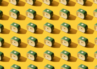 In this image for an article about how to wake up early, there are many old-school, identical green alarm clocks shown on top of a yellow background.