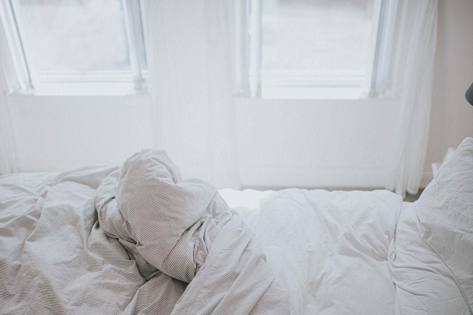 Scandinavian sleep method: Image of one half of a bed in sunny light.