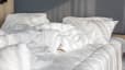 Scandinavian sleep method: Messy white blankets on a bed.