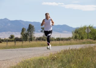 Woman runs on a path outdoors 