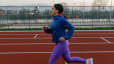Woman runs on a track outside, what muscles does running work