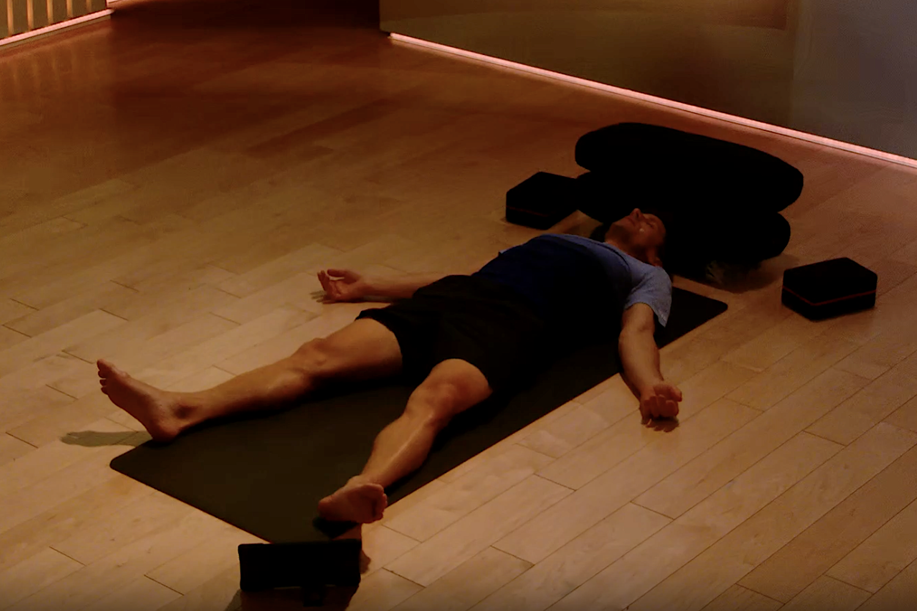 Denis Morton meditating and practicing savasana while lying down.
