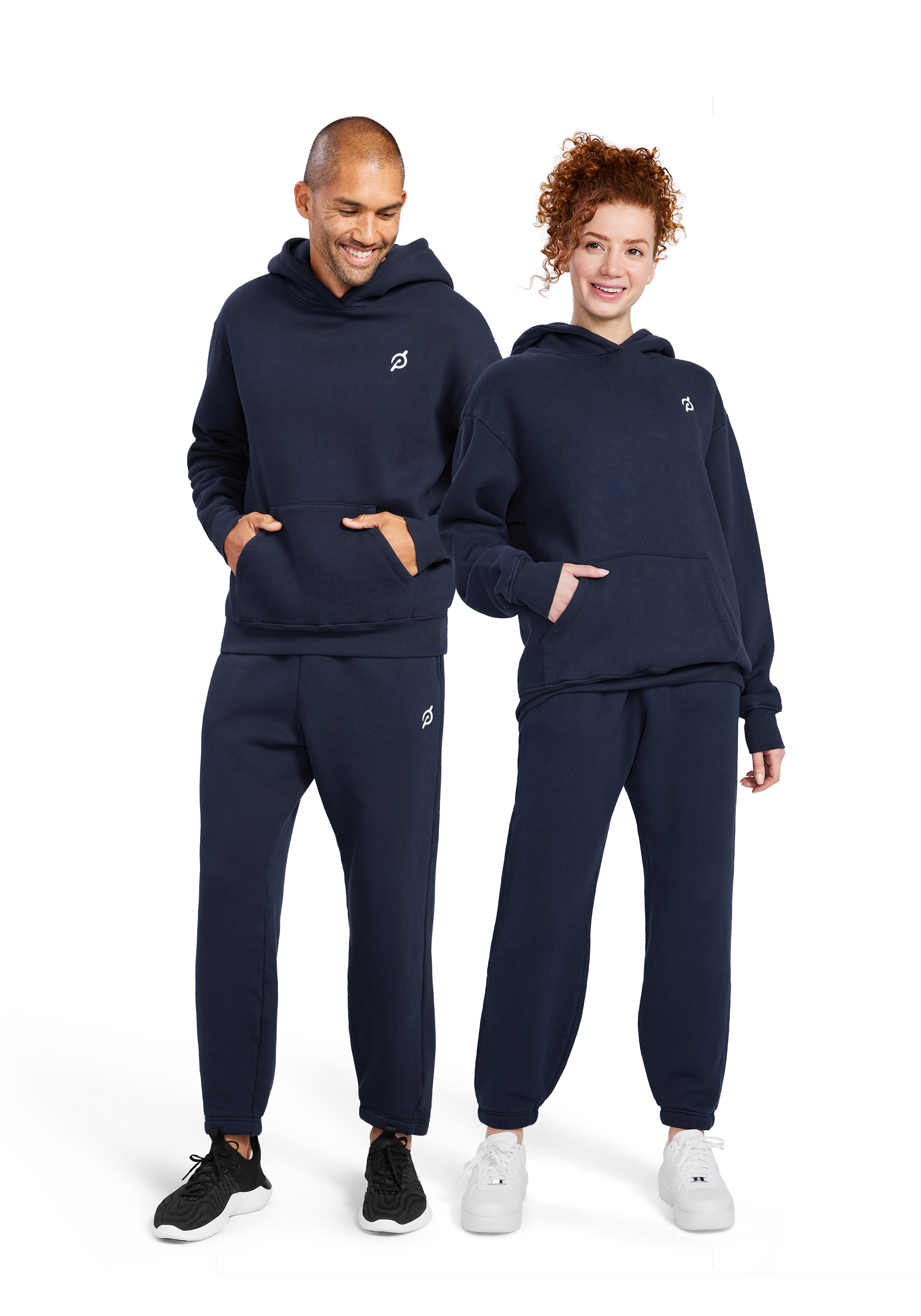 A man and woman modeling Fitness the Peloton Cooldown Fleece Hoodie and Sweatpant in navy